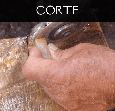 Mano realizando el corte artesanal de una pieza de calcedonia con una herramienta de disco.